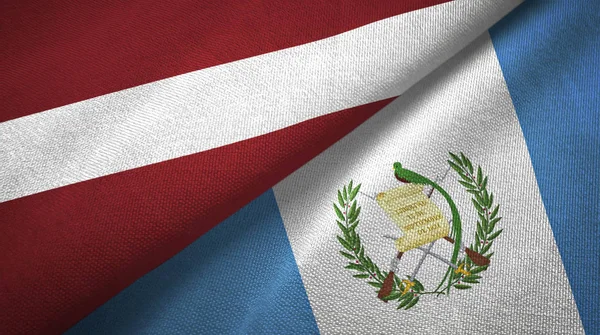 Letland en Guatemala twee vlaggen textiel doek, weefsel textuur — Stockfoto