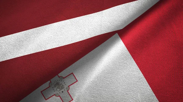 Letonia y Malta dos banderas tela textil, textura de la tela —  Fotos de Stock