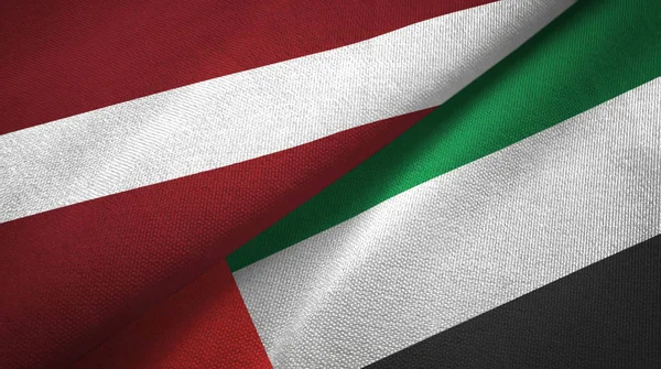Letonya ve Birleşik Arap Emirlikleri iki bayrak tekstil kumaş, kumaş doku — Stok fotoğraf