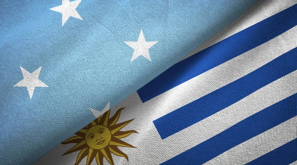 Микронезия и Уругвай два флага текстильная ткань, текстура ткани — стоковое фото