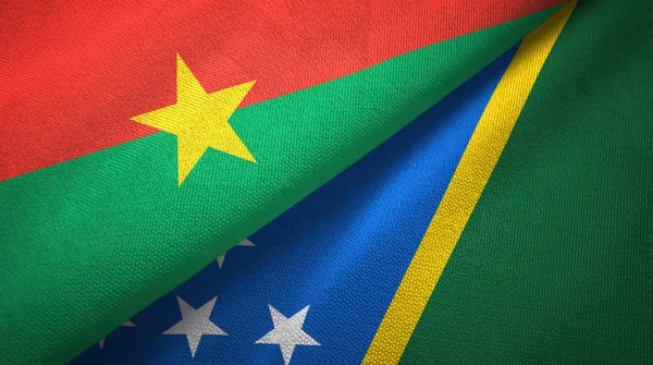Burkina Faso en Solomon eilanden twee vlaggen textiel doek, weefsel textuur — Stockfoto