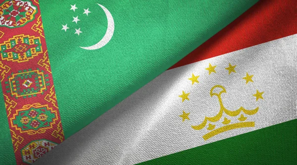 Turkmenistán y Tayikistán dos banderas tela textil, textura de la tela — Foto de Stock
