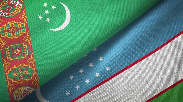 Turkmenistan och Uzbekistan två flaggor textil trasa, tyg textur — Stockfoto