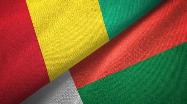 Гвинея и Мадагаскар два флага текстильная ткань, текстура ткани — стоковое фото