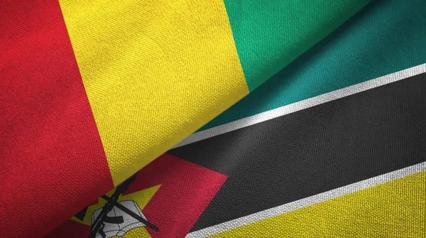 Guinea och Moçambique två flaggor textil trasa, tyg konsistens — Stockfoto