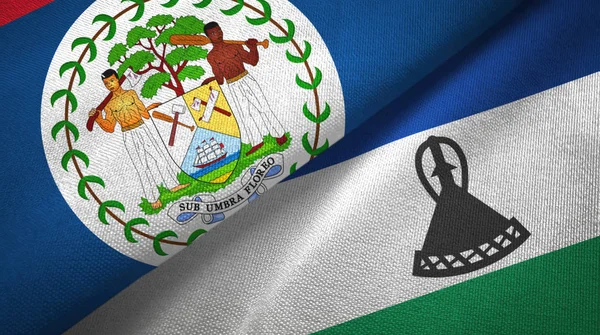Belize och Lesotho två flaggor textil tyg, tyg konsistens — Stockfoto