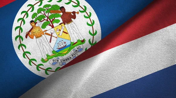 Belize i Holandia dwie flagi tkanina tekstylna, tekstura tkaniny — Zdjęcie stockowe