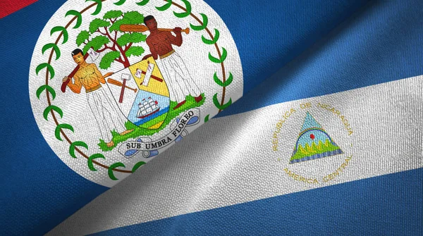 Belize i Nikaragua dwie flagi tkanina tekstylna, tekstura tkaniny — Zdjęcie stockowe