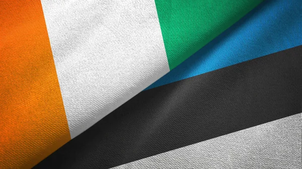 Cote Divoire och Estland två flaggor textil trasa, tyg textur — Stockfoto