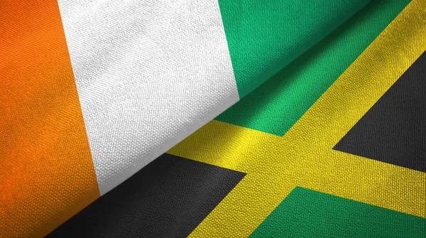 Cote divoire és Jamaica két zászló textil ruhával, szövet textúra — Stock Fotó