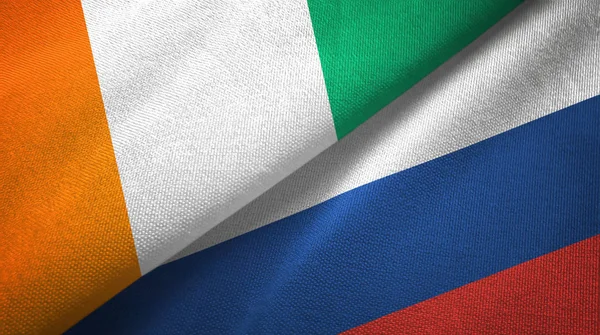 Cote DIVOIRE en Rusland twee vlaggen textiel doek, stof textuur — Stockfoto