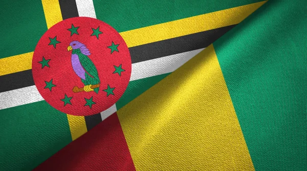 Dominica och Guinea två flaggor textil trasa, tyg konsistens — Stockfoto