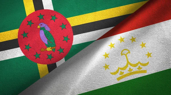 Dominique et le Tadjikistan deux drapeaux tissu textile, texture du tissu — Photo