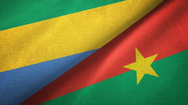 Gabon en Burkina Faso twee vlaggen textiel doek, stof textuur — Stockfoto
