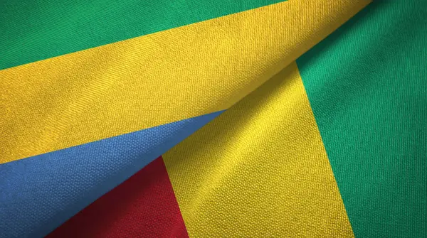 Gabon en Guinee twee vlaggen textiel doek, weefsel textuur — Stockfoto