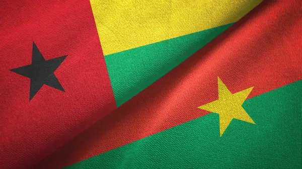 Guinea-Bissau und Burkina Faso zwei Flaggen Textilstoff, Textur — Stockfoto