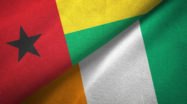Guinea-Bissau a Cote dIvoire Pobřeží slonoviny dvě vlajky textilní textilie — Stock fotografie