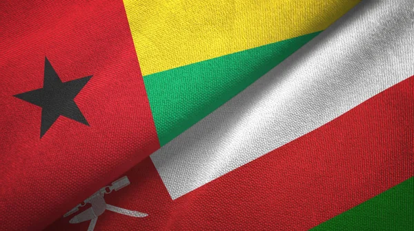 Guinea-Bissau und oman zwei Flaggen Textiltuch, Textilstruktur — Stockfoto