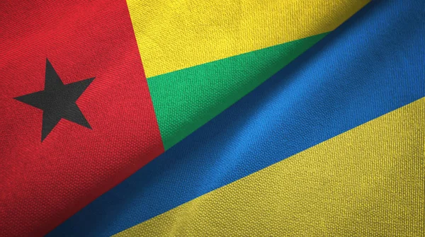 Guiné-Bissau e Ucrânia duas bandeiras de pano têxtil, textura de tecido — Fotografia de Stock