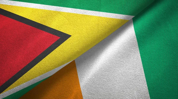 Guyana och Cote Divoire Ivory Coast två flaggor textil tyg textur — Stockfoto
