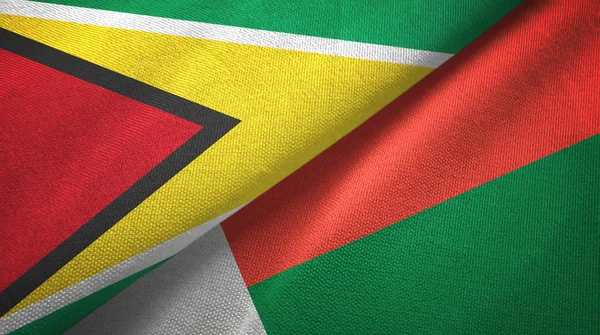 Guyana e Madagascar due bandiere tessuto, tessitura tessuto — Foto Stock