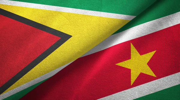 Guyana och Surinam två flaggor textil tyg, tyg konsistens — Stockfoto