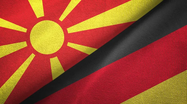 Macedonia del Norte y Alemania dos banderas tela textil, textura de la tela — Foto de Stock