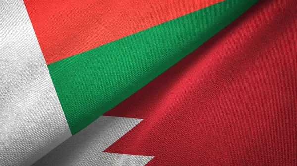 Madagascar and Bahrain two flags textile cloth, fabric texture — Stock Photo, Image