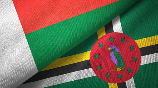 Madagascar et la Dominique deux drapeaux tissu textile, texture du tissu — Photo