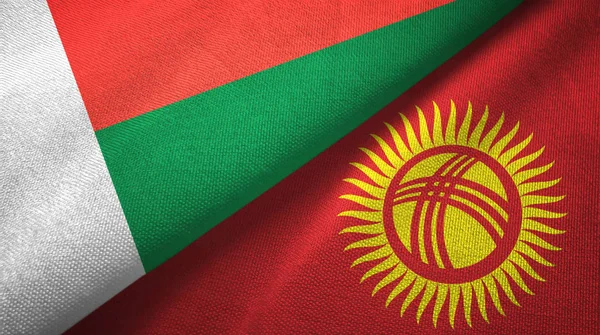 Madagaskar a Kyrgyzstán dvě vlajky textilní tkaniny, textura textilií — Stock fotografie