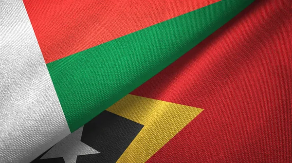 Madagáscar e Timor-Leste Timor-Leste duas bandeiras tecido têxtil, textura de tecido — Fotografia de Stock