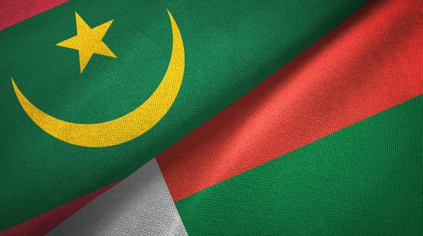 Mauritánia és Madagaszkár két zászló textil ruhával, szövet textúra — Stock Fotó