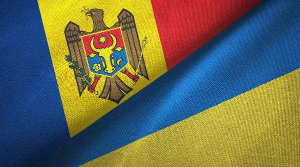 Moldávia e Ucrânia duas bandeiras de pano têxtil, textura de tecido — Fotografia de Stock