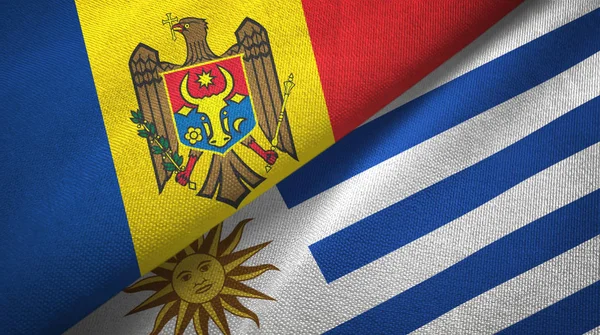 Moldavie et Uruguay deux drapeaux tissu textile, texture du tissu — Photo