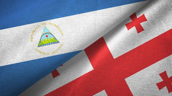Nicaragua and Georgia two flags textile cloth, fabric texture — Stock Photo, Image