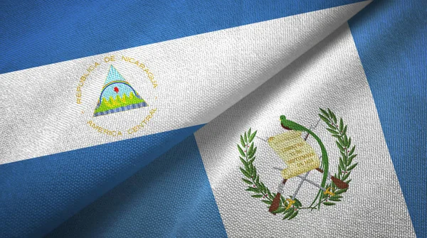 Nicarágua e Guatemala duas bandeiras de pano têxtil, textura de tecido — Fotografia de Stock