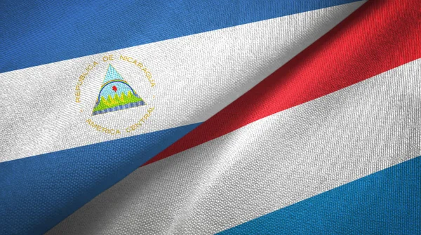 Nicarágua e Luxemburgo duas bandeiras pano têxtil, textura de tecido — Fotografia de Stock