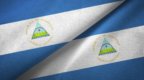 Nikaragua dvě vlajky textilní tkaniny, textura textilií — Stock fotografie