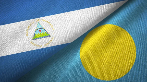 Nicarágua e Palau duas bandeiras de pano têxtil, textura de tecido — Fotografia de Stock
