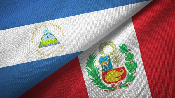 Nicarágua e Peru duas bandeiras de pano têxtil, textura de tecido — Fotografia de Stock