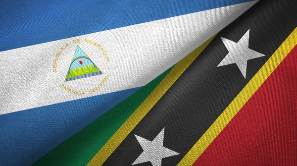 Nicaragua en Saint Kitts en Nevis twee vlaggen textiel doek, stof textuur — Stockfoto
