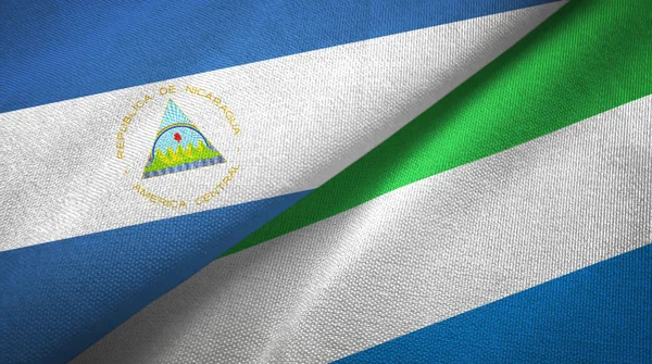 Nicaragua and Sierra Leone two flags textile cloth, fabric texture — Stock Photo, Image
