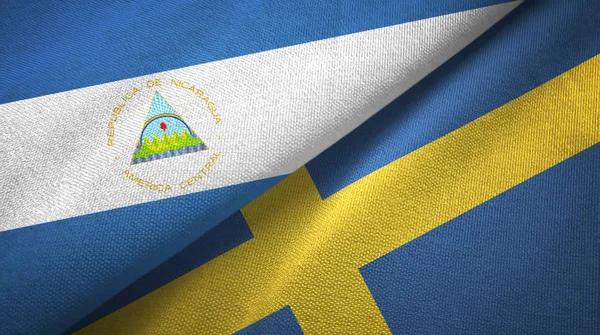 Nikaragua a Švédsko dvě vlajky textilní tkaniny, textura textilií — Stock fotografie
