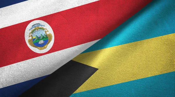 Costa Rica en Bahama's twee vlaggen textiel doek, stof textuur — Stockfoto