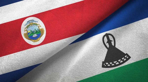 Costa Rica et Lesotho deux drapeaux tissu textile, texture du tissu — Photo