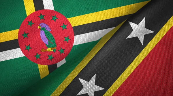 Dominique et Saint-Kitts-et-Nevis deux drapeaux tissu textile, texture du tissu — Photo