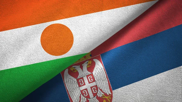 Niger i Serbia dwie flagi tkanina tekstylna, tekstura tkaniny — Zdjęcie stockowe