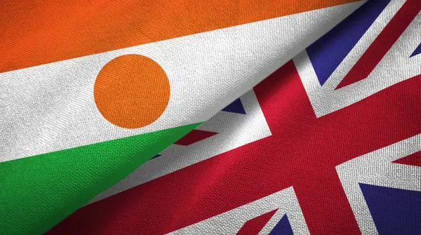 Níger e Reino Unido duas bandeiras de pano têxtil, textura de tecido — Fotografia de Stock