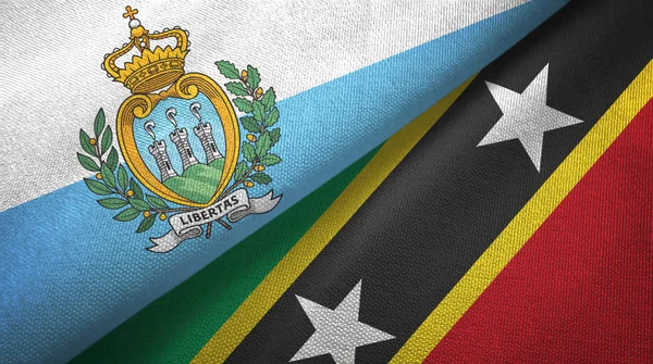 San Marino en Saint Kitts en Nevis twee vlaggen textiel doek, stof textuur — Stockfoto