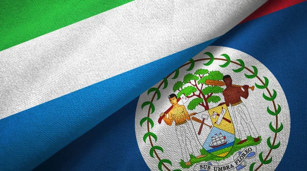 Serra Leoa e Belize duas bandeiras de pano têxtil, textura de tecido — Fotografia de Stock